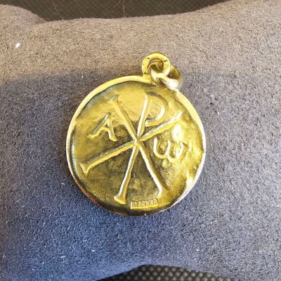 une médaille d'or posée sur un oreiller posé par terre