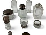 a group of glass bottles and a ring on a white surface
