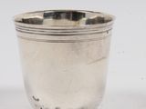 une photo d'une coupe en argent posée sur une table blanche