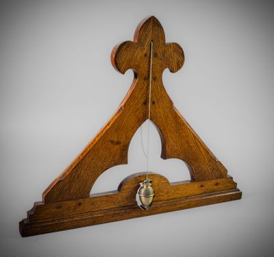 an image of a wooden clock with a bell hanging from it ' s side