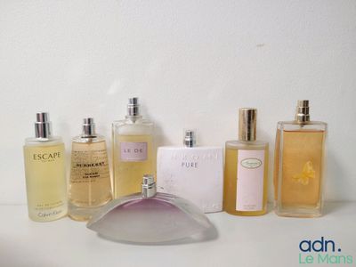 plusieurs flacons de parfum posés les uns à côté des autres sur un plan de travail