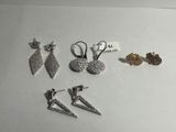 cinq paires de boucles d'oreilles et une paire de boucles d'oreilles posées sur une table
