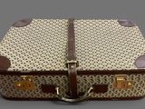 a brown and white suitcase sitting on top of a table