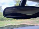 a rear view mirror of a car with a person in it