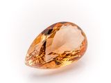 a close up of an orange diamond on a white surface