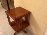 a small wooden table with a mirror on the wall