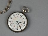 a pocket watch with a chain around it on a table
