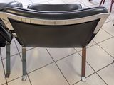 a black leather chair sitting in the middle of a room