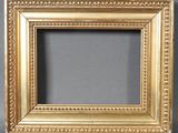 a gold picture frame on a gray background