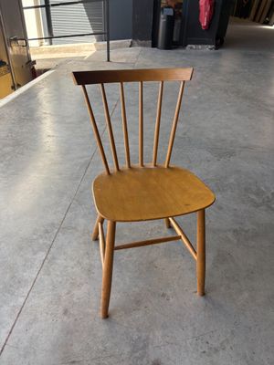 une chaise en bois posée sur le sol en béton