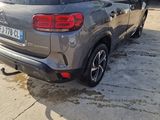 the rear end of a grey car parked in a garage