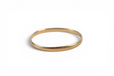 gros plan d'une bague en or sur fond blanc