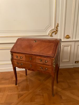 a small wooden desk with a drawer on top of it