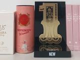 three boxes of perfumes and a clock on a table