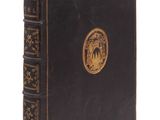 un vieux livre noir orné d'un emblème doré sur la couverture