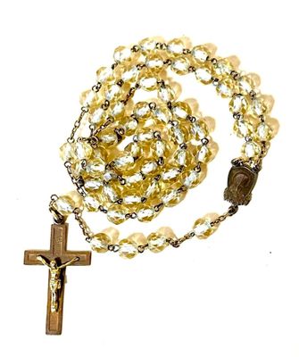 yellow glass rosary with a wooden cross on a white background