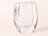 un vase en verre posé sur une surface blanche