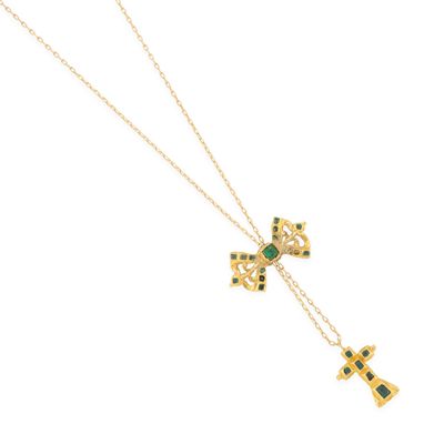 Gros plan sur un collier en or orné d'une croix