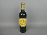 the bottle of wine is sitting on the table with a gray background