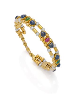 un bracelet en or orné de pierres multicolores et de perles