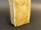an old book sitting on top of a table next to a gray background
