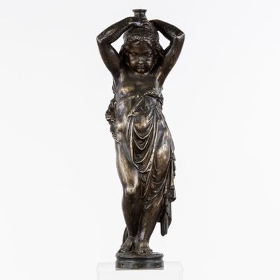 une statue en bronze représentant une femme tenant un panier sur la tête