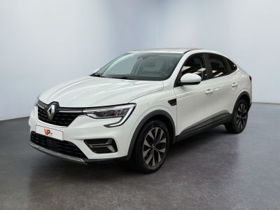 Une voiture blanche est garée dans une pièce au sol noir.