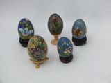 several different colored eggs are sitting on a stand on a white surface