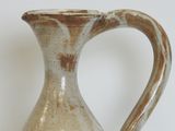 a brown and white vase sitting on a table