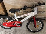 a red and white bike that is next to a box