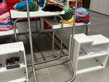 une table sur laquelle sont posés quelques vêtements, dans une pièce