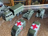 several toy army vehicles are sitting on a table next to a dresser
