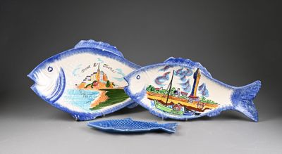 two fish shaped dishes on display on a table