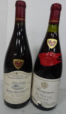 two bottles of wine sitting next to each other on a table
