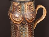 a brown and blue vase sitting on a wooden table