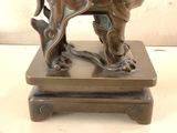 a bronze statue of an elephant on a wooden base