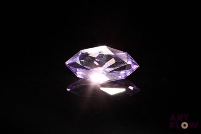 gros plan d'un diamant violet sur une surface noire