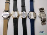 four different watches are lined up on a white surface