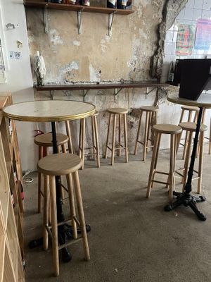 tables and stools in a small room with a laptop on a stand
