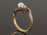a close up of a gold ring with a pearl and diamonds