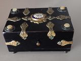 a small black box with gold decorations on top of it