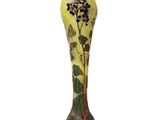 yellow and green vase with flowers and leaves on it on a white background