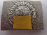 an old silver belt buckle with a yellow label on it