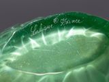 a close up of a green glass vase with writing on it