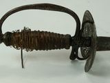 a very old sword that is on a white surface