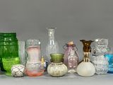 de nombreux vases en verre de différentes couleurs posés sur la table