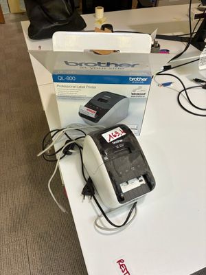 une table blanche sur laquelle se trouvent un téléphone noir et une boîte