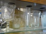 de nombreux verres et tasses posés sur une étagère en verre dans un placard