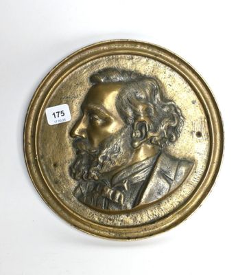 une image représentant un médaillon en bronze sur lequel figure le visage d'un homme