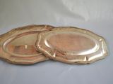two gold coasters sitting on a white table